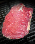 Rohes Flanksteak Creekstone Farms USA auf dem Grill mit deutlicher Fleischstruktur