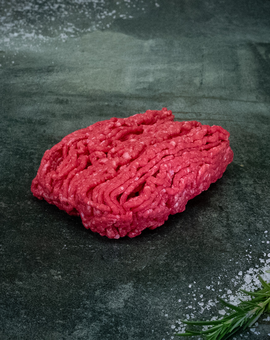 Hackfleisch vom Rind – Feine Marmorierung für vollen Geschmack Frisches Hackfleisch vom Rind – Färse aus Pommern auf einem Holzbrett