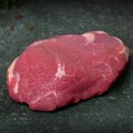 Lammhüfte aus Neuseeland auf Holzbrett angerichtet