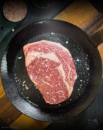 Rohes Ribeye Creekstone Farms USA mit deutlicher Marmorierung in der Pfanne