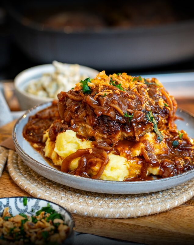 Dieses Gericht ist ein echtes Comfort-Food-Highlight: Zwiebelrostfrikadellen mit geschmorten Zwiebeln und einer richtig würzigen, braunen Soße.