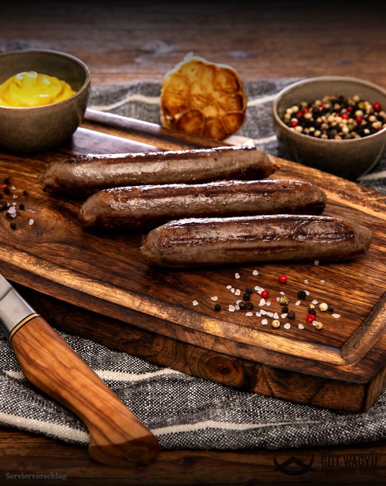 Zubereitete Wagyu Bratwurst aus Deutschland mit goldbrauner Kruste auf rustikalem Holzbrett angerichtet