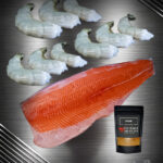 Seafood Grill Bundle mit Lachsseite und Black Tiger Garnelen roh auf hochwertigem dunklem Hintergrund