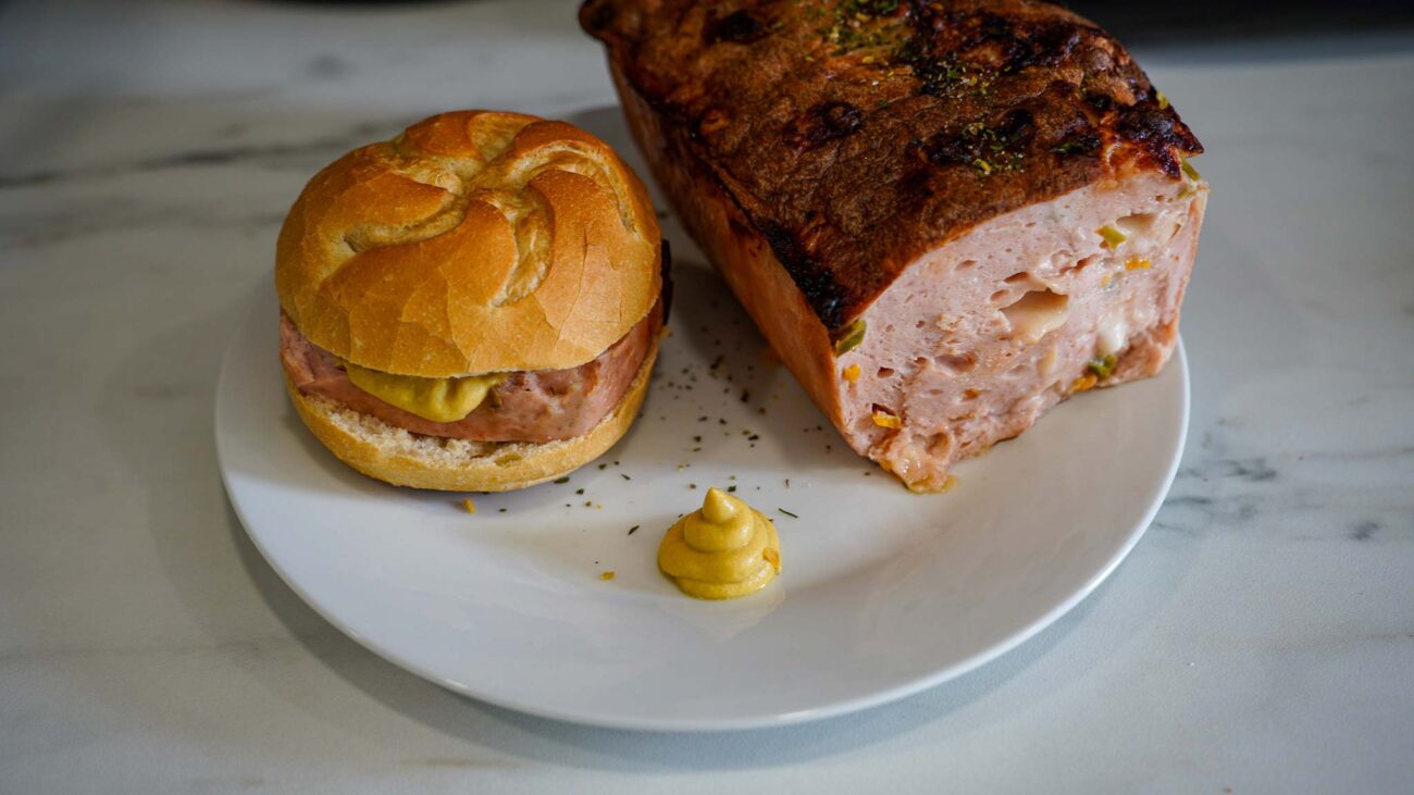 Leberkäse im Brötchen mit Senf auf schlichtem Hintergrund – klassisch, herzhaft und frisch serviert.