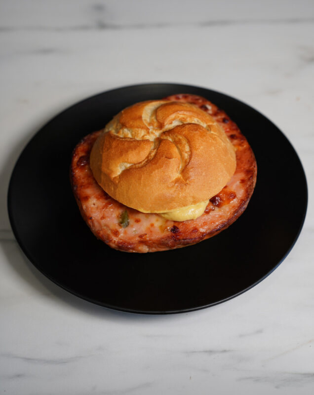 Leberkäse im Brötchen mit Senf auf schlichtem Hintergrund – klassisch, herzhaft und frisch serviert.