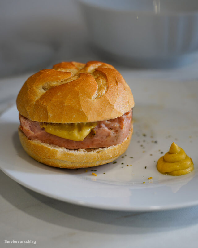 Leberkäse im Brötchen mit Senf auf schlichtem Hintergrund – klassisch, herzhaft und frisch serviert.